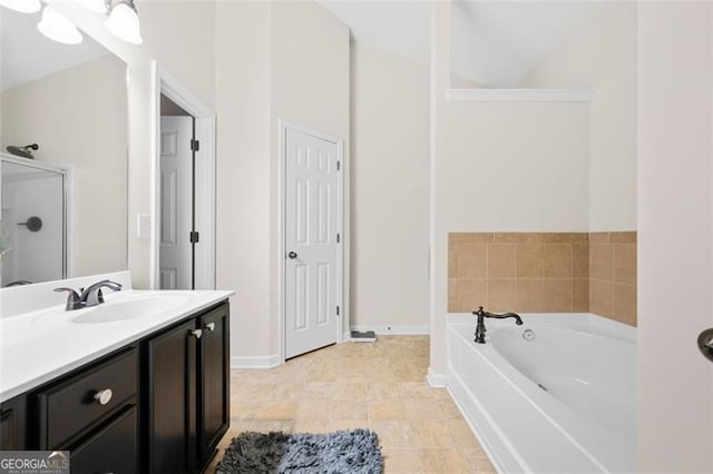 full bathroom with vanity, a bath, and baseboards