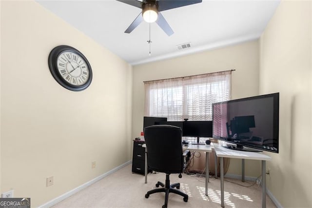 office space with baseboards, visible vents, ceiling fan, and light colored carpet