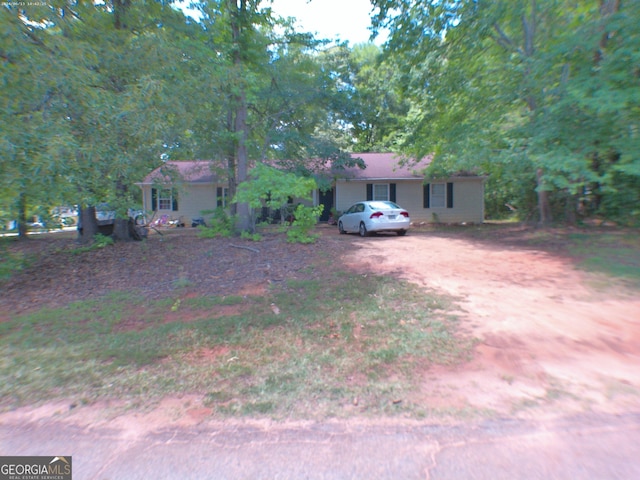 ranch-style house with dirt driveway