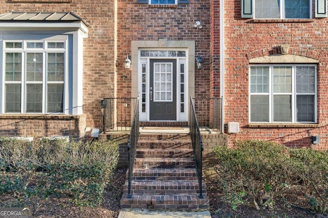 property entrance with brick siding and a standing seam roof