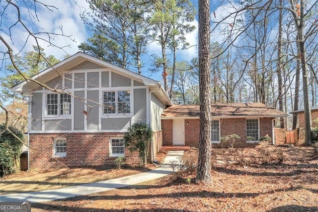 view of front of home with a sunroom, brick siding, and stucco siding