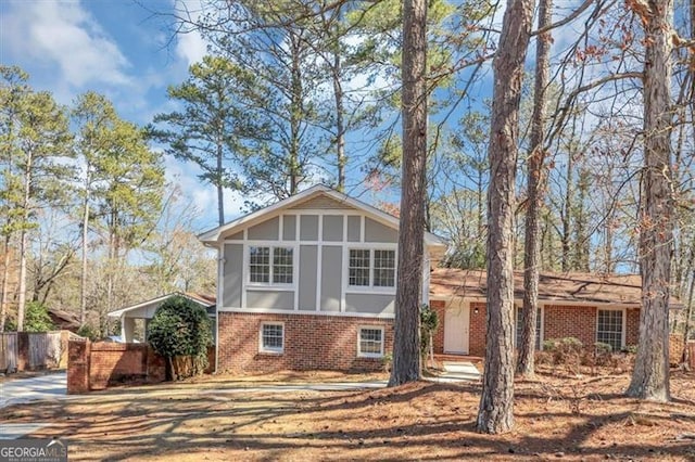 tri-level home with fence and brick siding