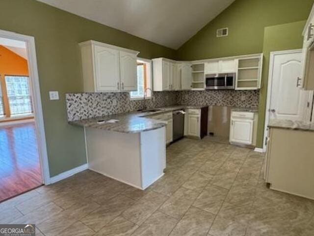 kitchen with open shelves, stainless steel appliances, lofted ceiling, decorative backsplash, and white cabinets