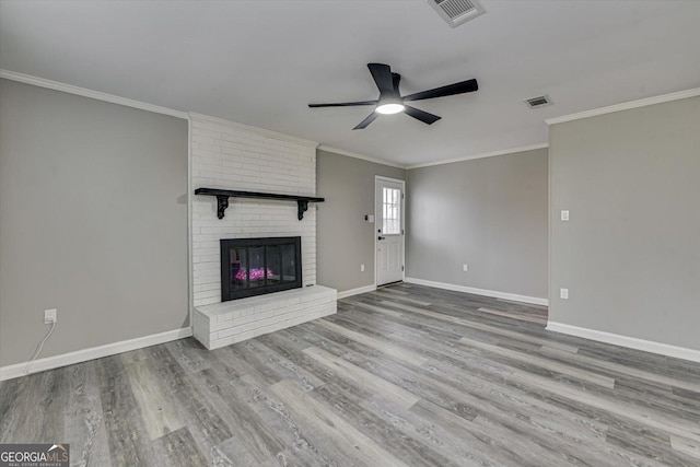 unfurnished living room with light wood-type flooring, a fireplace, visible vents, and baseboards