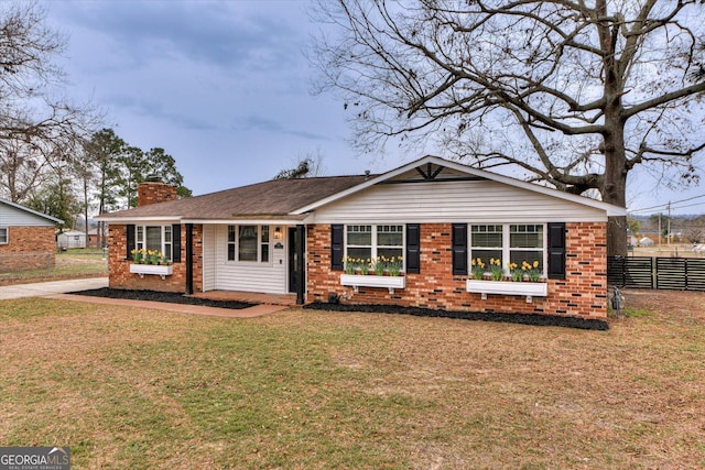 single story home featuring a chimney, a front yard, fence, and brick siding