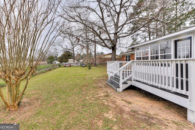 view of yard with a sunroom, a fenced backyard, and a wooden deck