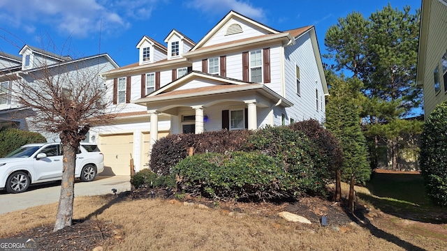 view of front facade with a porch, driveway, and an attached garage