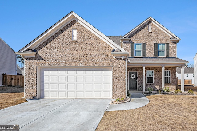 traditional-style house featuring driveway, brick siding, an attached garage, and fence