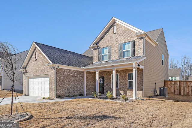 traditional-style home featuring driveway, a garage, fence, cooling unit, and brick siding