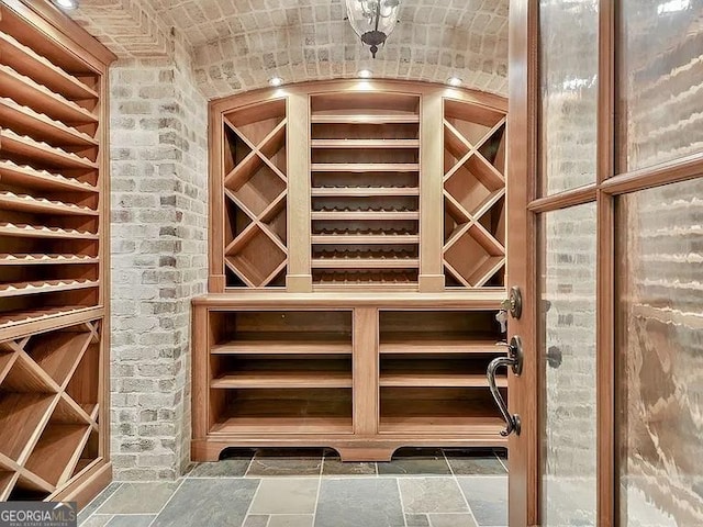 wine cellar featuring brick wall and stone tile floors