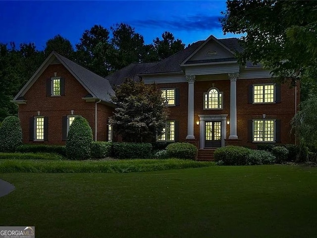 view of front of house featuring a front yard, french doors, and brick siding