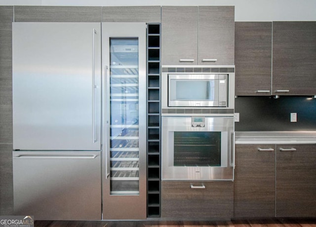 kitchen with stainless steel appliances, dark brown cabinets, and modern cabinets