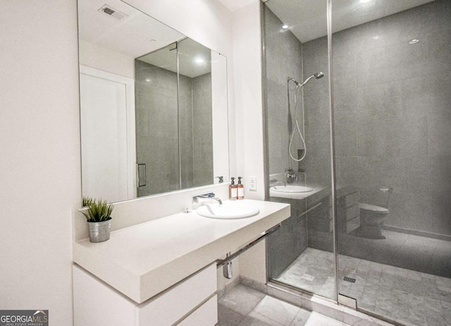 full bathroom with toilet, a sink, visible vents, and a shower stall