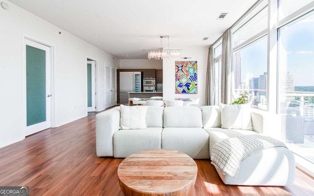 living room with a view of city, plenty of natural light, baseboards, and wood finished floors