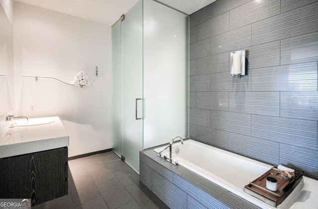 full bath featuring baseboards, tile patterned floors, a garden tub, vanity, and a shower stall