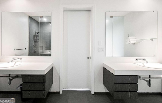 full bath with a sink, a shower stall, baseboards, and tile patterned floors