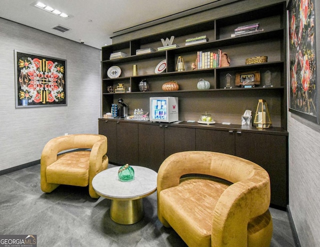 living area with baseboards and visible vents