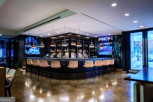 bar featuring finished concrete floors, recessed lighting, and a dry bar