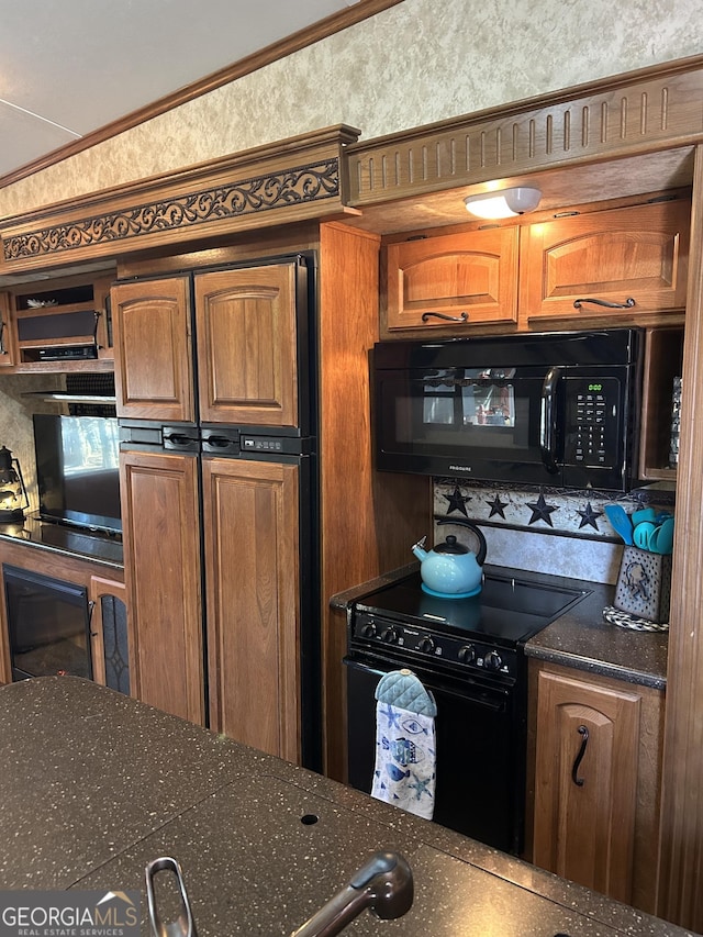 kitchen featuring brown cabinetry, dark countertops, and black appliances