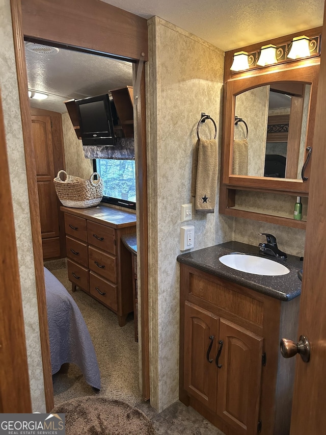 bathroom with a textured ceiling and vanity