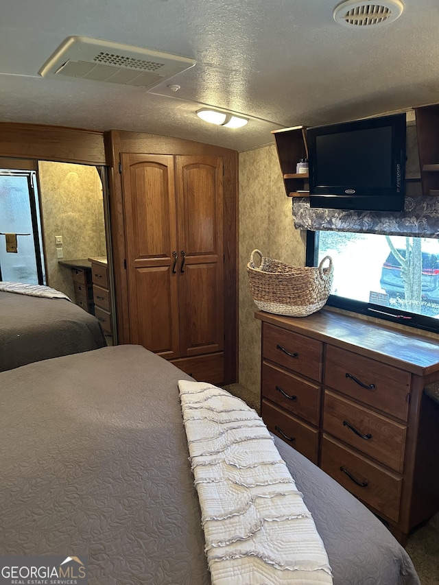 bedroom featuring visible vents and a textured ceiling