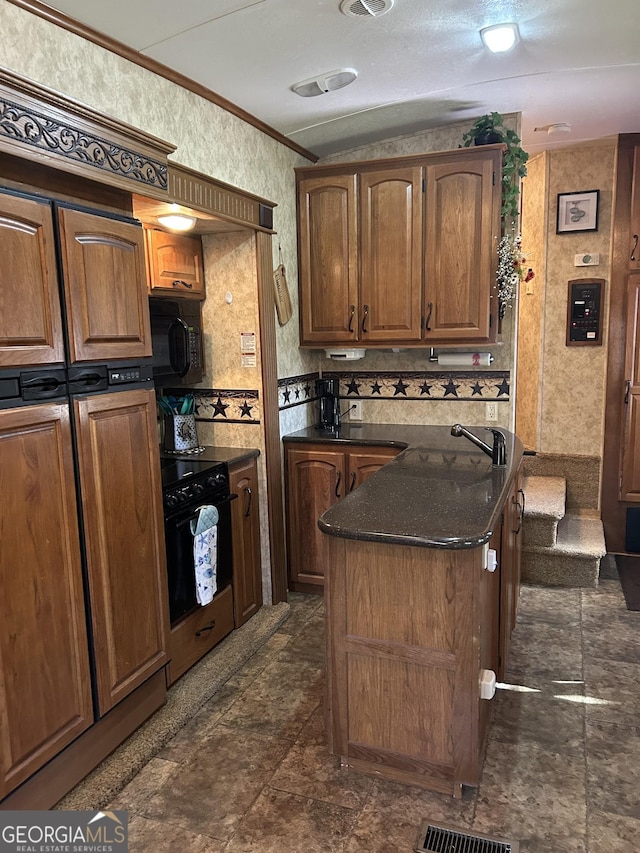 kitchen featuring black microwave, wall oven, visible vents, a center island, and crown molding