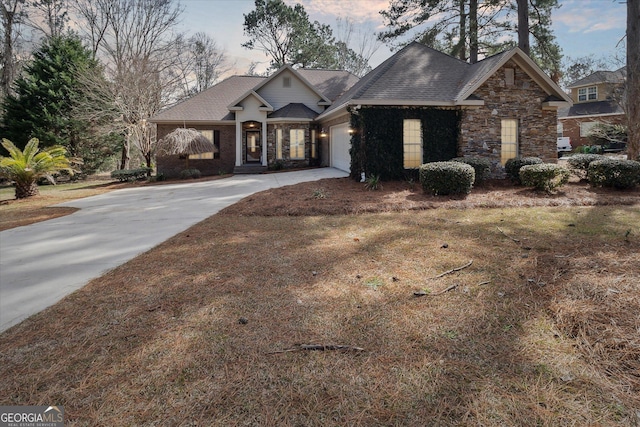 craftsman-style home featuring a garage, stone siding, roof with shingles, and driveway