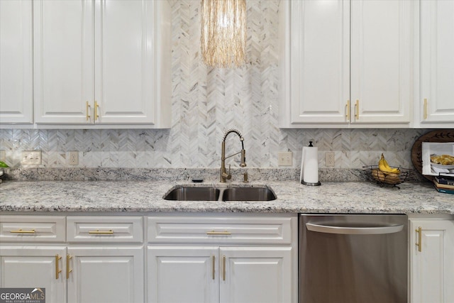 kitchen with tasteful backsplash, stainless steel dishwasher, a sink, and white cabinets