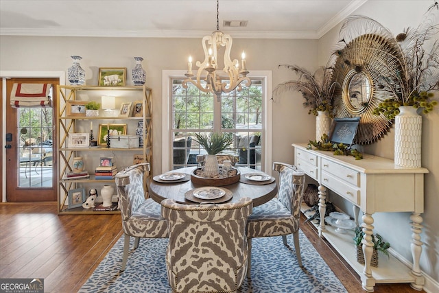 dining room featuring an inviting chandelier, plenty of natural light, dark wood finished floors, and crown molding