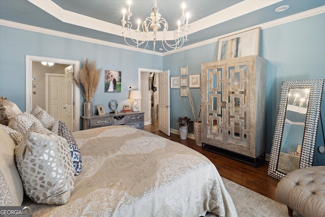 bedroom with dark wood-type flooring, a tray ceiling, crown molding, and an inviting chandelier