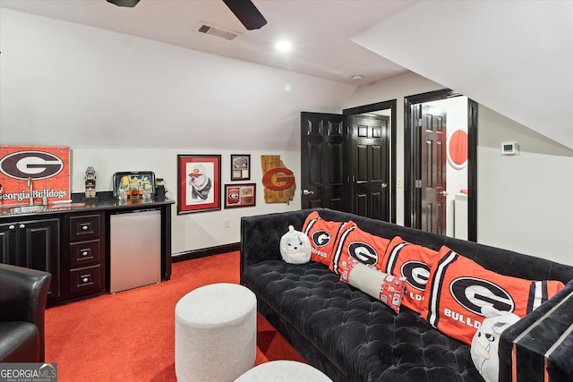 cinema room with light carpet, lofted ceiling, visible vents, and baseboards