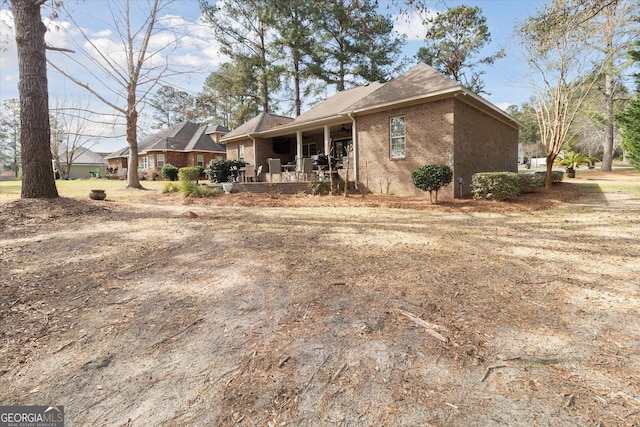 back of property featuring brick siding