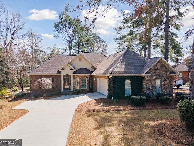 view of front facade with a garage, driveway, and roof with shingles