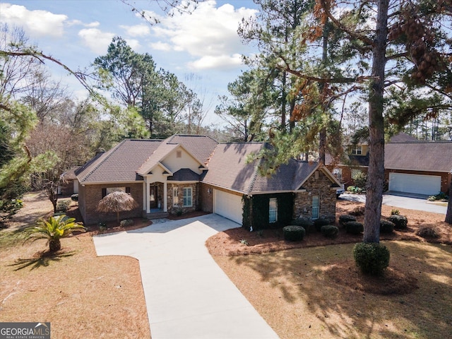 view of front facade featuring concrete driveway, stone siding, and an attached garage