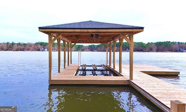 dock area with a water view and boat lift