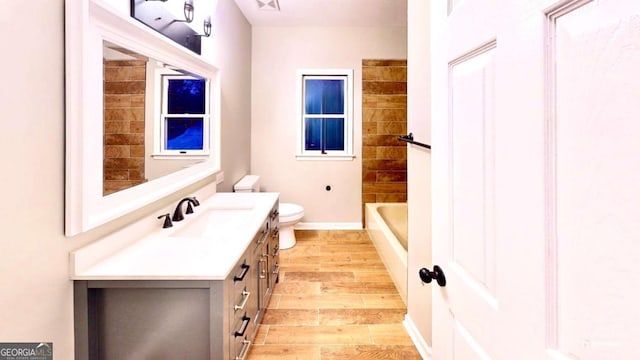 full bath with shower / tub combination, toilet, wood finished floors, vanity, and baseboards