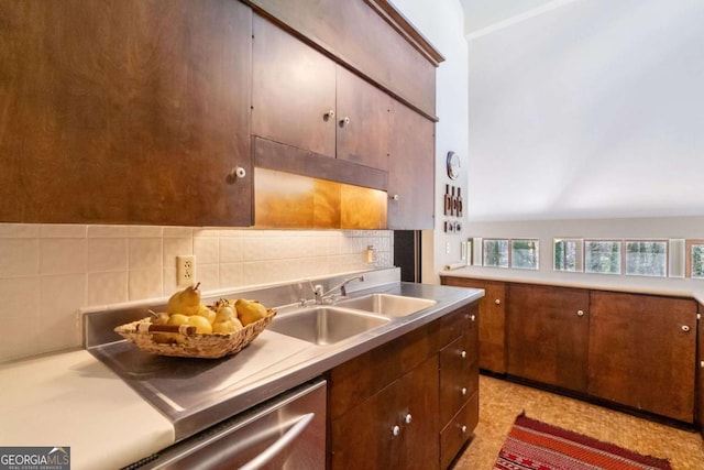 kitchen with tasteful backsplash, light countertops, a sink, and light floors