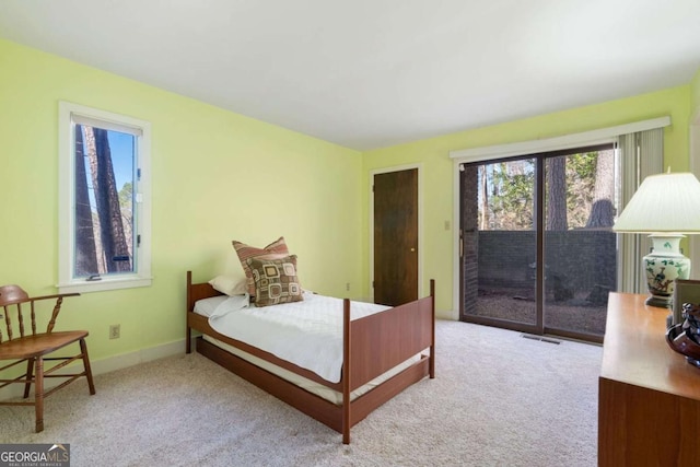 bedroom with baseboards, access to outside, visible vents, and light colored carpet