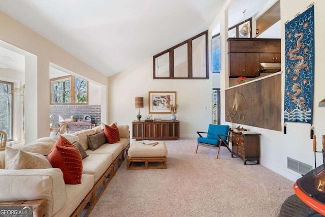 living room with lofted ceiling, light carpet, visible vents, and baseboards