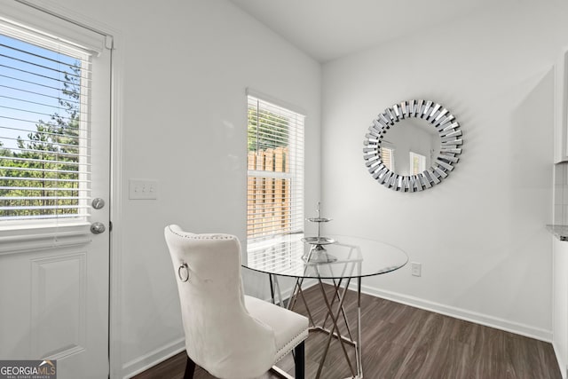 dining area with baseboards and dark wood finished floors