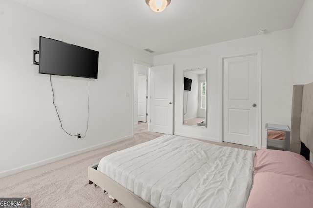 bedroom with light colored carpet and baseboards