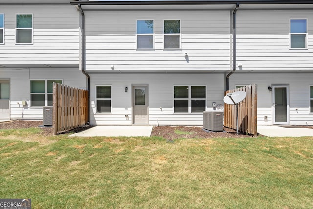 back of property with a yard, a patio, cooling unit, and fence