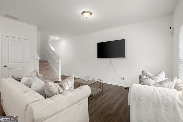 living room with stairs, dark wood finished floors, visible vents, and baseboards