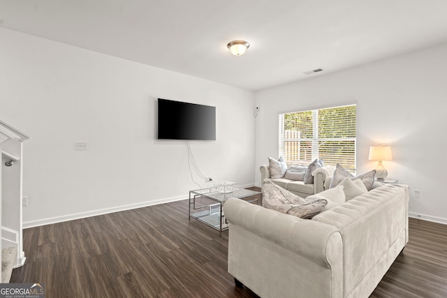 living room with dark wood-type flooring, visible vents, and baseboards