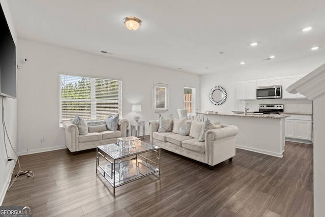 living room featuring dark wood-type flooring, recessed lighting, visible vents, and baseboards