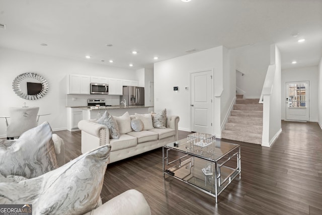 living area with dark wood-style floors, baseboards, stairway, and recessed lighting