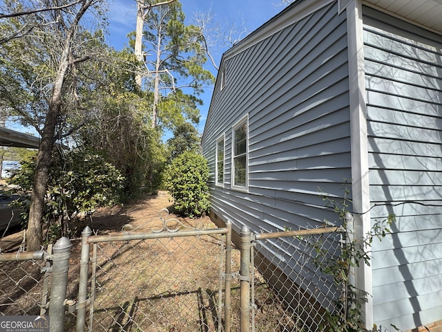 view of side of home with a gate and fence