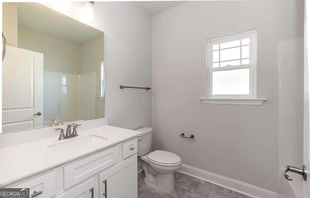 full bathroom with toilet, baseboards, a shower, and vanity