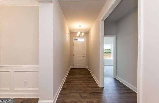 corridor with baseboards and dark wood-type flooring