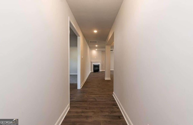 hallway featuring dark wood-type flooring, recessed lighting, visible vents, and baseboards